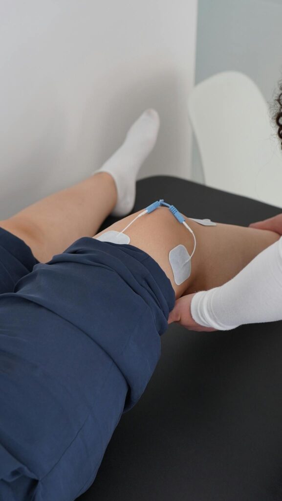Electrotherapy applied during a knee physiotherapy session for muscle recovery.
